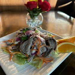 Thai Table - Nam Tok Beef ... Grilled sliced meat tossed w/onion, mint , cilantro and roasted rice Powder in chili lime dressing