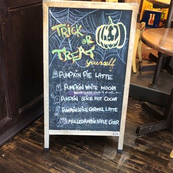 Java Sun - A chalkboard menu with Halloween decorations, including a pumpkin and spider web, listing pumpkin-flavored coffee drinks. - Coffee & Tea Near Me - Marblehead, Massachusetts