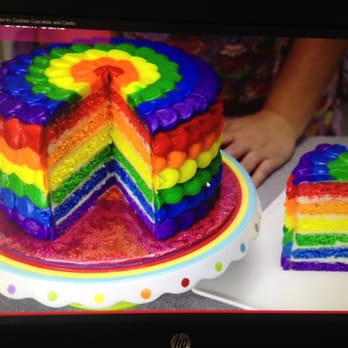 Beth's Bakery - a rainbow cake with a slice taken out of it - Bakeries Near Me