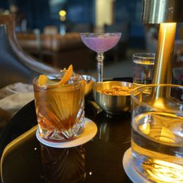 a glass of alcohol and a drink on a table a glass of alcohol and a drink on a table