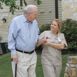 Caring Senior Service - Caregiver and Senior walking into home.