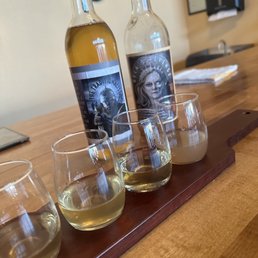 three glasses of wine and a bottle of wine