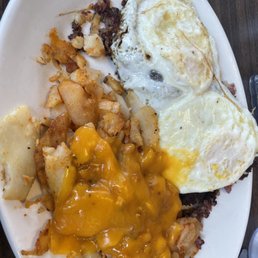 Two eggs over corned beef hash, with cheese on the potatoes Two eggs over corned beef hash, with cheese on the potatoes