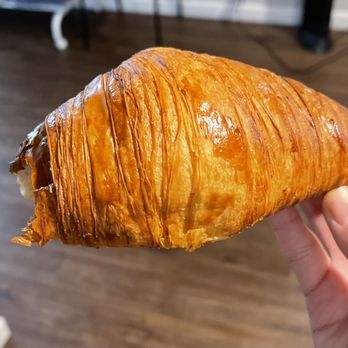 Roast’d Coffee - a hand holding a pastry - Coffee & Tea Near Me - Hasbrouck Heights, New Jersey