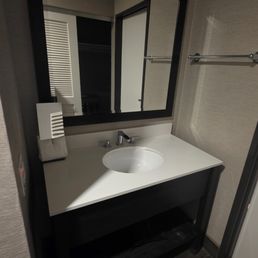 Lavatory outside the bathroom with no handsoap, lotion, toothbrush, and toothpaste.