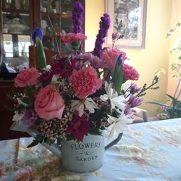 Assorted flowers in watering can vase
