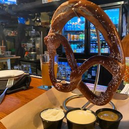 Giant pretzel worn three dipping sauces - beer cheese, mustard and goat cheese Giant pretzel worn three dipping sauces - beer cheese, mustard and goat cheese