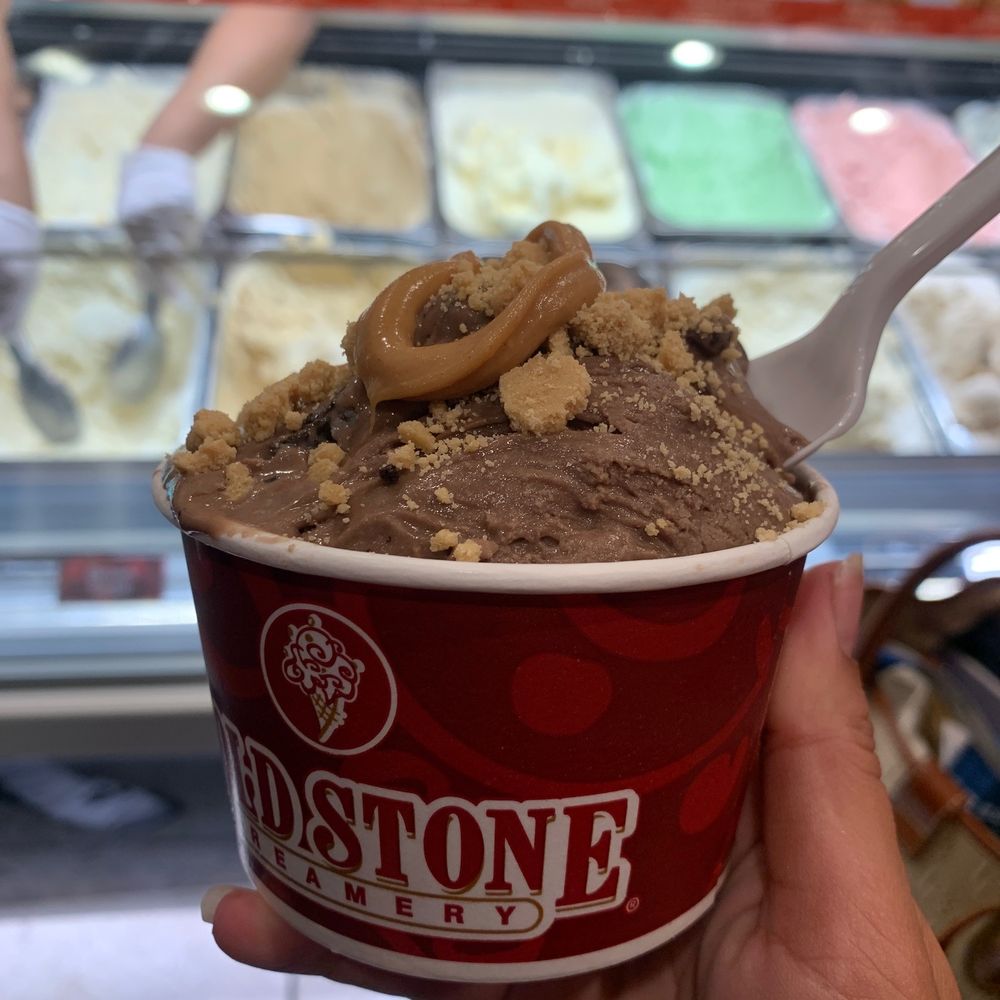 a hand holding a cup of ice cream a hand holding a cup of ice cream