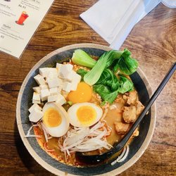 Spicy umami miso ramen with tofu, karaage, and a soft-boiled egg,