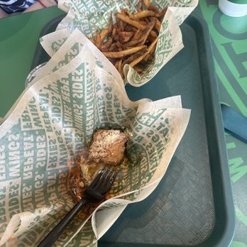 Wingstop - 6 piece Small 6 pc Wing Combo - French fries and a piece of fried chicken are served on a tray with branded paper at Wingstop in Niles, IL. - Chicken Wings Near Me - Niles, Illinois