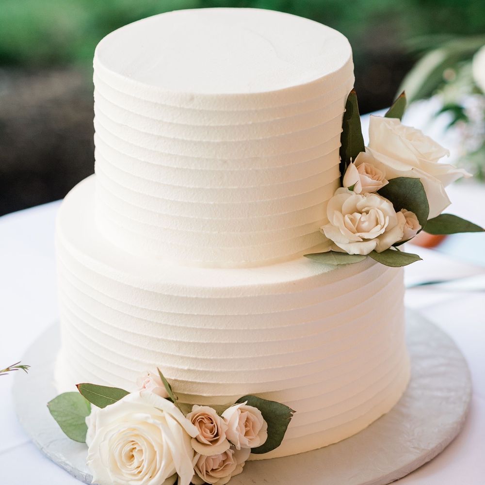 a white wedding cake with flowers a white wedding cake with flowers