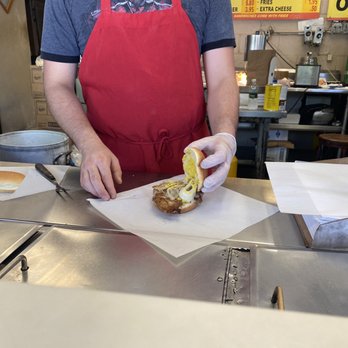 Maxwells - a man preparing a sandwich in a kitchen - American Near Me - Chicago, Illinois Maxwells - a man preparing a sandwich in a kitchen - American Near Me - Chicago, Illinois