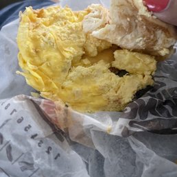 a hand holding a half eaten sandwich