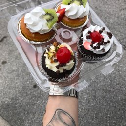 a person holding a tray of cupcakes a person holding a tray of cupcakes