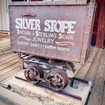 Virginia City - An old mining cart doubles a shop sign - Local Flavor Near Me Virginia City - An old mining cart doubles a shop sign - Local Flavor Near Me