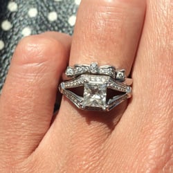 Custom bow ring sitting pretty atop the engagement ring from another jeweler.