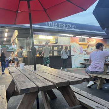 The Freeze - a woman sitting at a picnic table under an umbrella - Ice Cream & Frozen Yogurt Near Me - Grayslake, Illinois The Freeze - a woman sitting at a picnic table under an umbrella - Ice Cream & Frozen Yogurt Near Me - Grayslake, Illinois