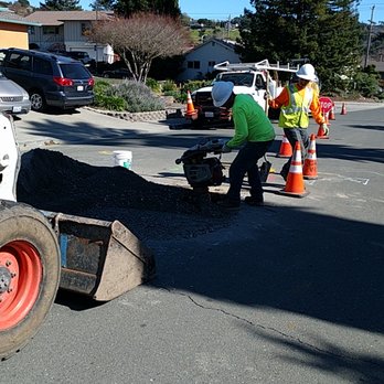 Glosage Engineering - Compressing the dirt to refill the street access hole. - Septic Services Near Me