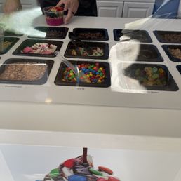 a man standing in front of an ice cream counter a man standing in front of an ice cream counter