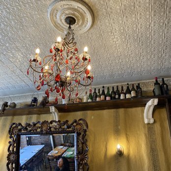 Frank - a chandelier and wine bottles on a wall - Italian Near Me - New York, New York Frank - a chandelier and wine bottles on a wall - Italian Near Me - New York, New York
