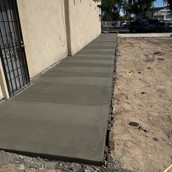 Hibbs Construction - a concrete sidewalk being laid in front of a building - Handyman Near Me