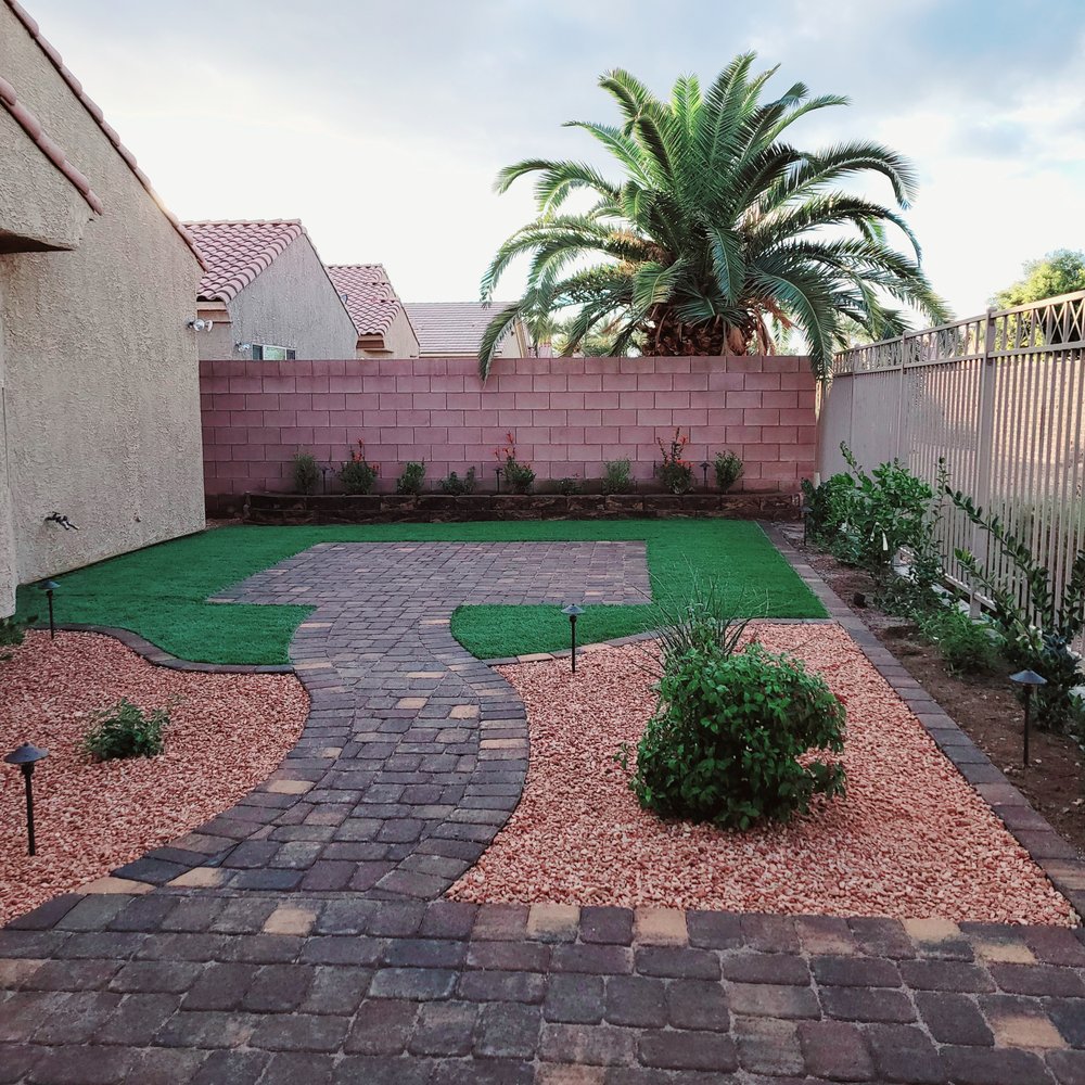 Keny’s Landscaping - a backyard with a brick path and a palm tree - Landscaping Near Me - Las Vegas, Nevada