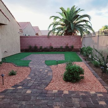 Keny’s Landscaping - a backyard with a brick path and a palm tree - Landscaping Near Me - Las Vegas, Nevada