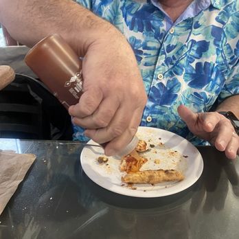 Hook & Ladder Pizza - My husband drizzling this yummy goodness on his crust - Pizza Near Me - Hollister, Missouri