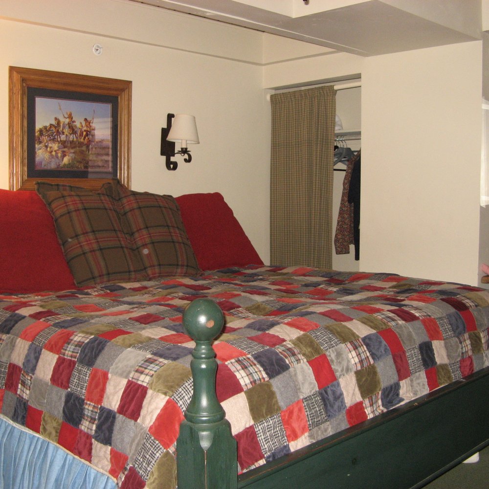 Little Red Ski Haus - a bed with a colorful blanket - Hotels Near Me - Aspen, Colorado Little Red Ski Haus - a bed with a colorful blanket - Hotels Near Me - Aspen, Colorado