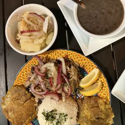 Pierna de Cerdo Asada Marinated roasted pork, Fried Plantains, Yuka, & Beans. Pierna de Cerdo Asada Marinated roasted pork, Fried Plantains, Yuka, & Beans.