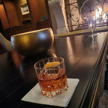 Addison - Bourbon old fashioned next to the fireplace - New American Near Me - San Diego, California