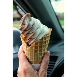 a person holding an ice cream cone a person holding an ice cream cone