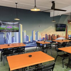 The Railyard - Covered patio with TV's and mural of the Houston skyline