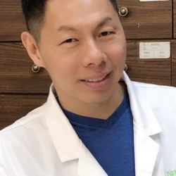 Soho Acupuncture Center - Diem Truong in front of the herbal cabinets