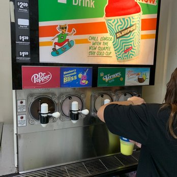 7-Eleven - a woman filling a cup of ice cream into a machine - Convenience Stores Near Me - Macomb Township, Michigan