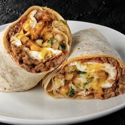 Fuego Cravings - A 13" flour tortilla packed with savory asada, crispy bacon, fluffy eggs, hearty beans, golden fries, melted cheese, fresh onion, & cilantro