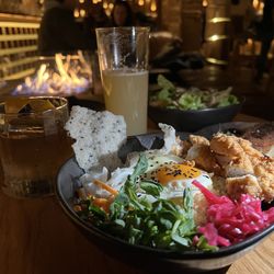 The Den Salamanca - Fried spiced chicken, fried egg, edamame, daikon, carrot, red cabbage, pea sprouts, & tapioca crisps on a bed of warm rice.