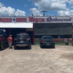 two cars parked in front of a restaurant two cars parked in front of a restaurant