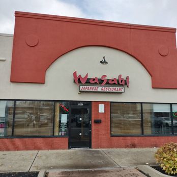 Wasabi - Outside view - Exterior view of Wasabi Japanese restaurant, featuring a red and white facade, large windows with blinds, and a black door with an 'Open' sign. - Sushi Bars Near Me - Amherst, New York