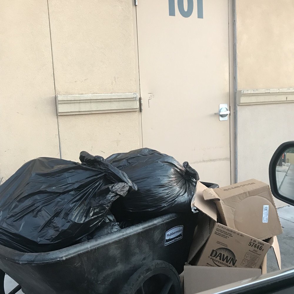 a wheelbarrow full of garbage outside of a building a wheelbarrow full of garbage outside of a building