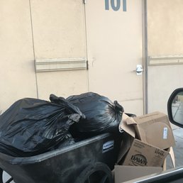 a wheelbarrow full of garbage outside of a building a wheelbarrow full of garbage outside of a building