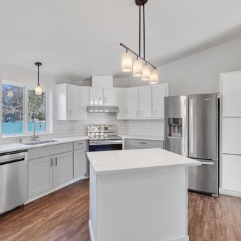 Lux Renovations - a kitchen with white cabinets and stainless steel appliances - General Contractors Near Me Lux Renovations - a kitchen with white cabinets and stainless steel appliances - General Contractors Near Me