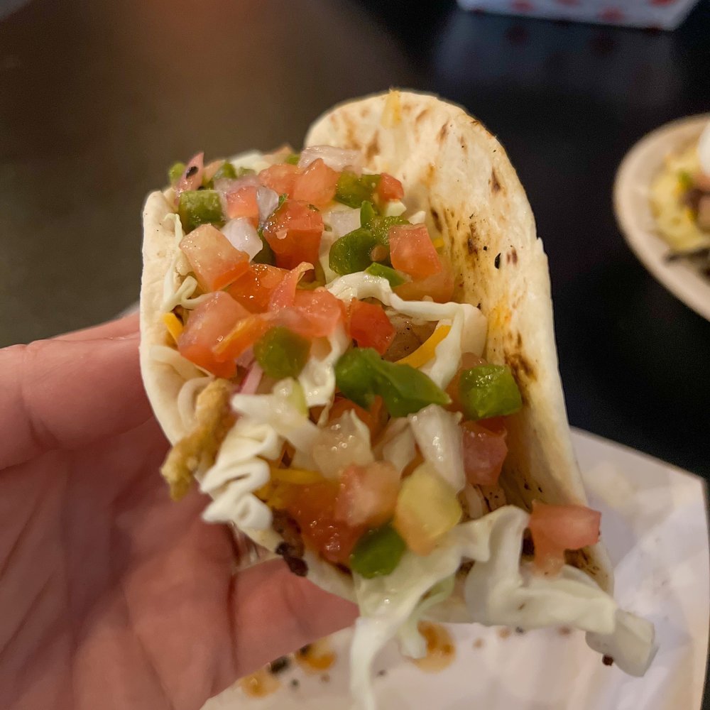 H3SH3R BBQ - a hand holding a taco - Food Trucks Near Me