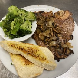 T T-Bone Steak with mushrooms and grilled onions! Steamed broccoli! - A meal featuring a T-bone steak topped with sautéed mushrooms and grilled onions, served with steamed broccoli and toasted bread slices.