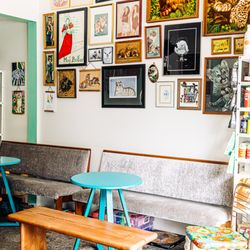Idle Wine And Goods - curated wall, seated area for guests to drink wine.
