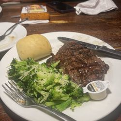 Hickory House Restaurant - Medium Ribeye Steak with a side of steamed Broccoli and a dinner roll.