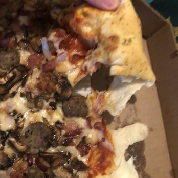 Pizza Hut - a person taking a slice of pizza - Pizza Near Me - Maricopa, Arizona
