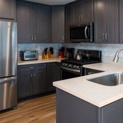 E&E Cabinets - Grey shaker cabinets with off white quartz countertops and herringbone backsplash.