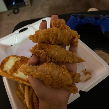 Raising Cane’s - Stafford - a hand holding a tray of fried chicken strips - Chicken Shop Near Me - Stafford, Texas