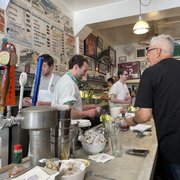 Photo of Swan Oyster Depot - San Francisco, CA, United States. Happy and merry customers and servers at the bar